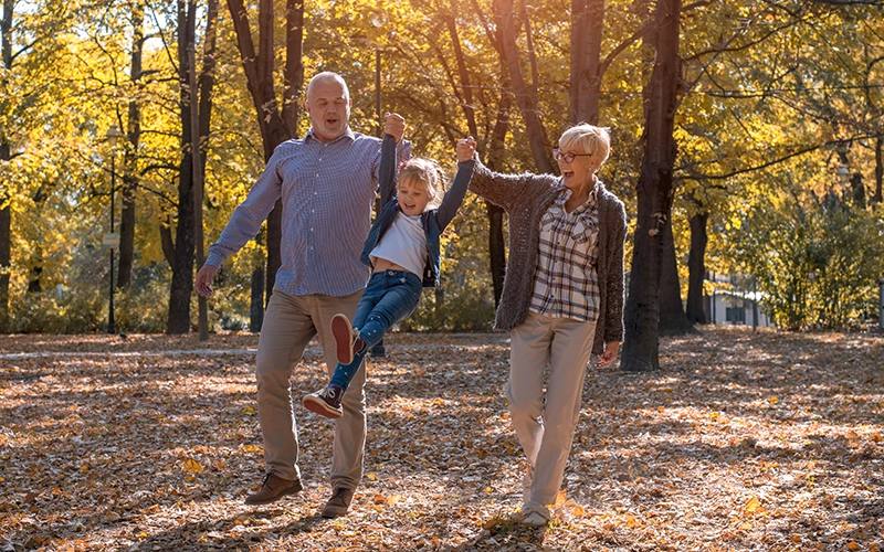 Dos abuelos paseando con su nieta, simbolizando la protección del derecho patrimonial y sucesorio.