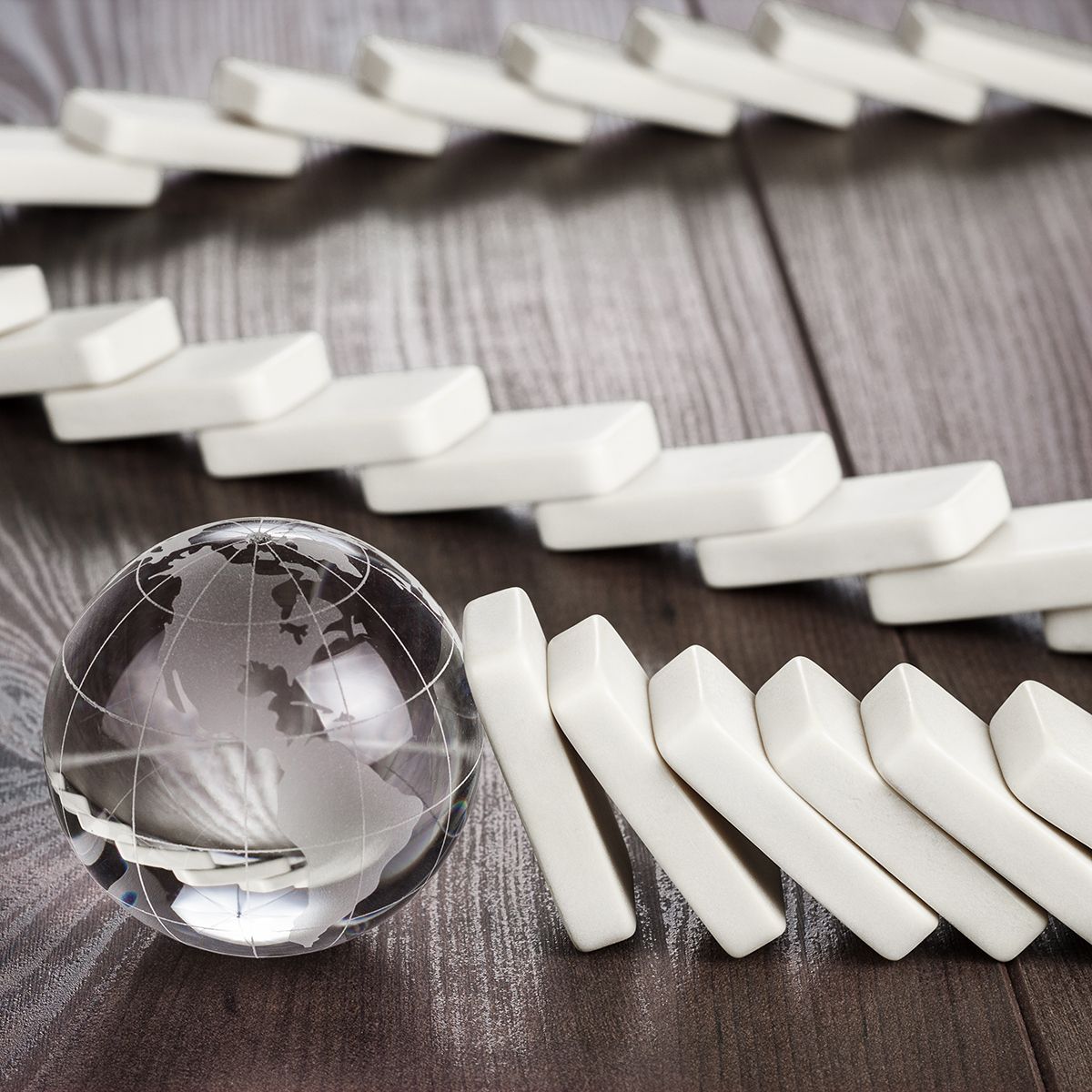 Piezas cayendo que terminan en una bola de cristal que representa la Tierra.