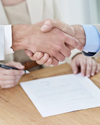 Apretón de manos tras la firma de un acuerdo.